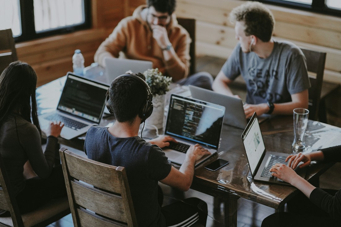Professionals collaborating around a laptop